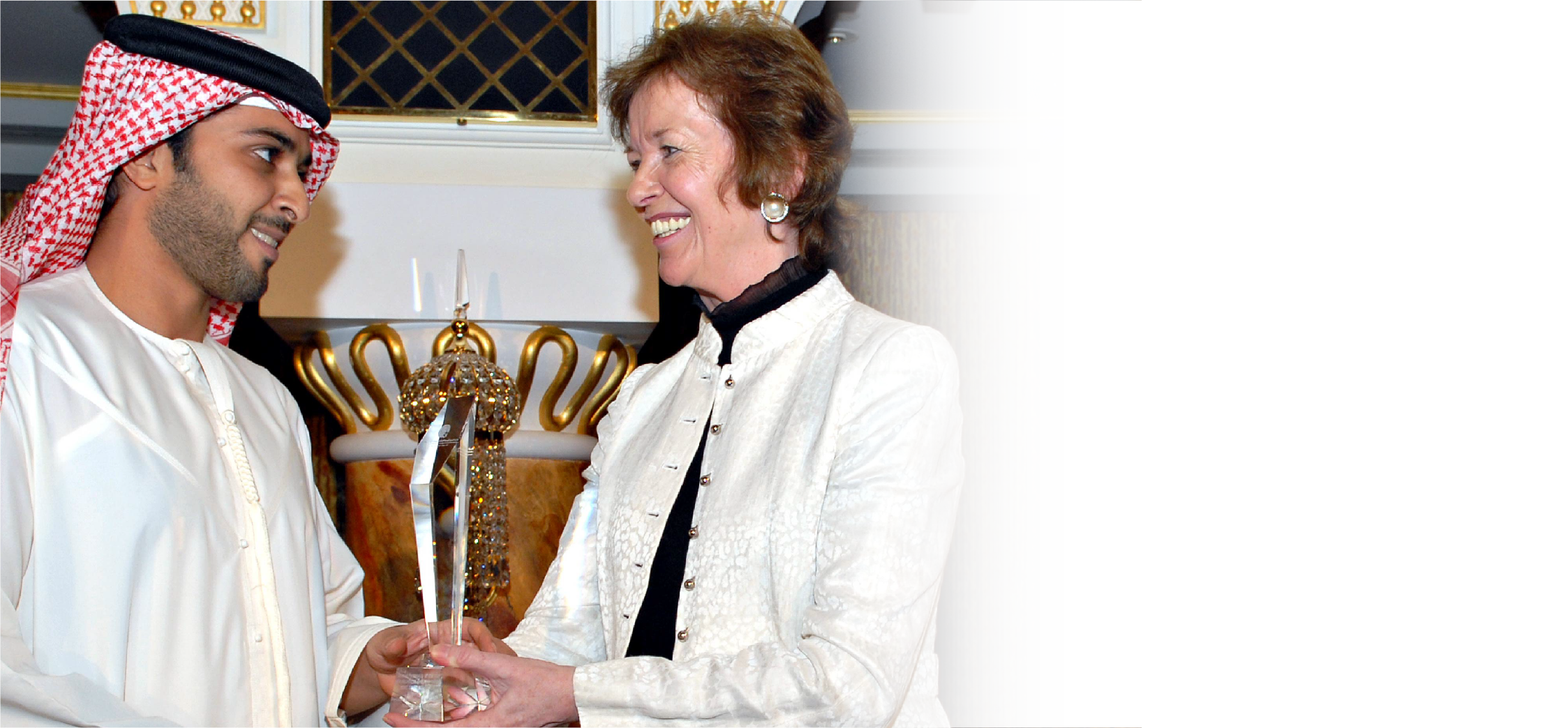 Leaders exchanging a crystal award at a Middle East Excellence Awards ceremony
